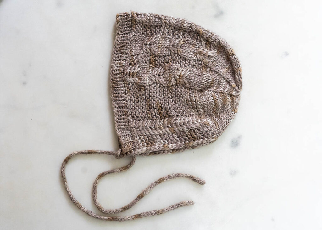a hand knitted silk bonnet for a new baby