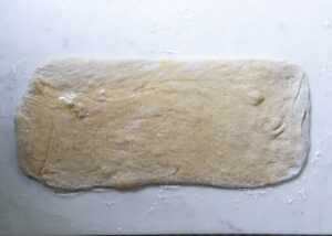 sourdough rolled out on a counter and brushed with butter