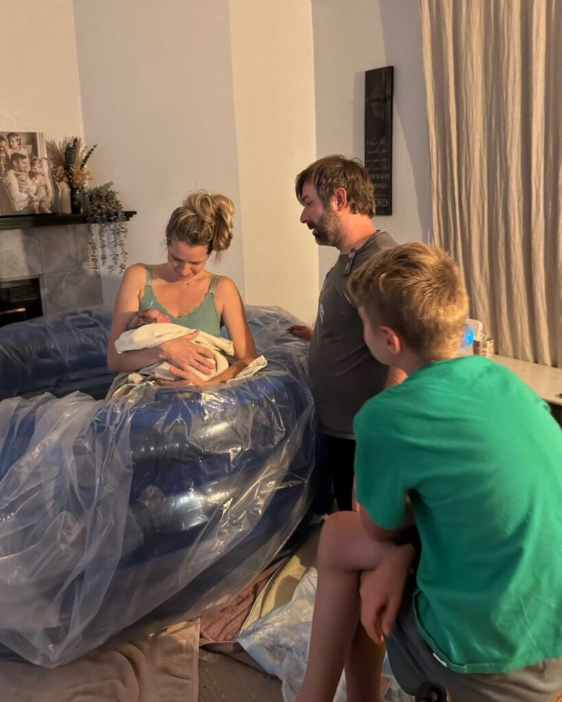 Holding my new baby in the birth tub after our homebirth